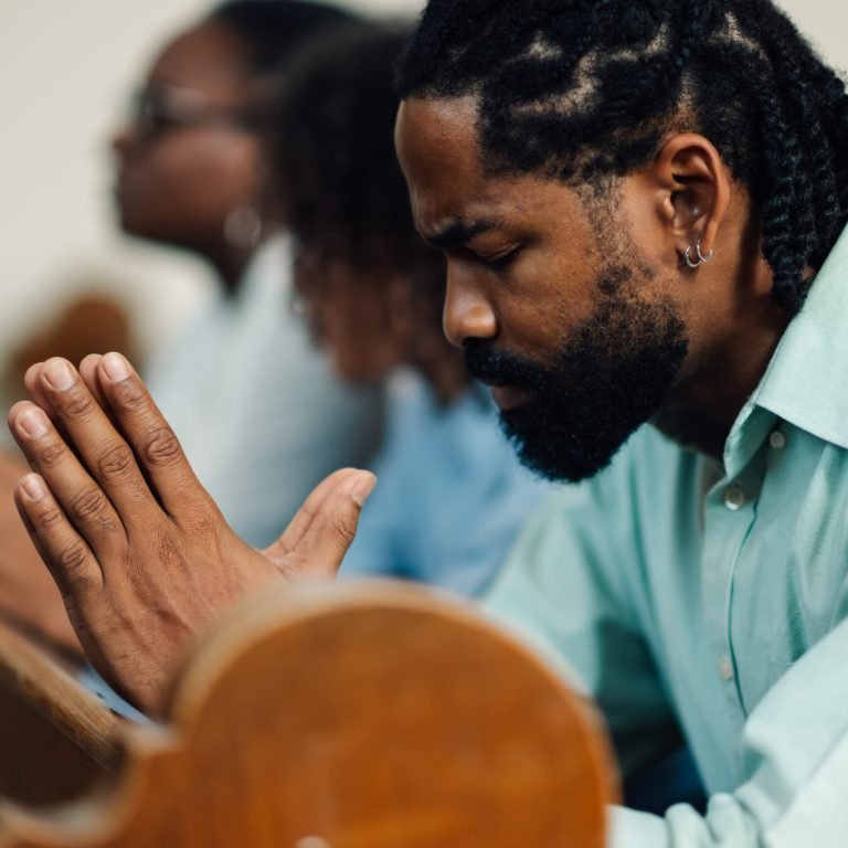 African american father leads family in prayer at church, showing deep faith and togetherness